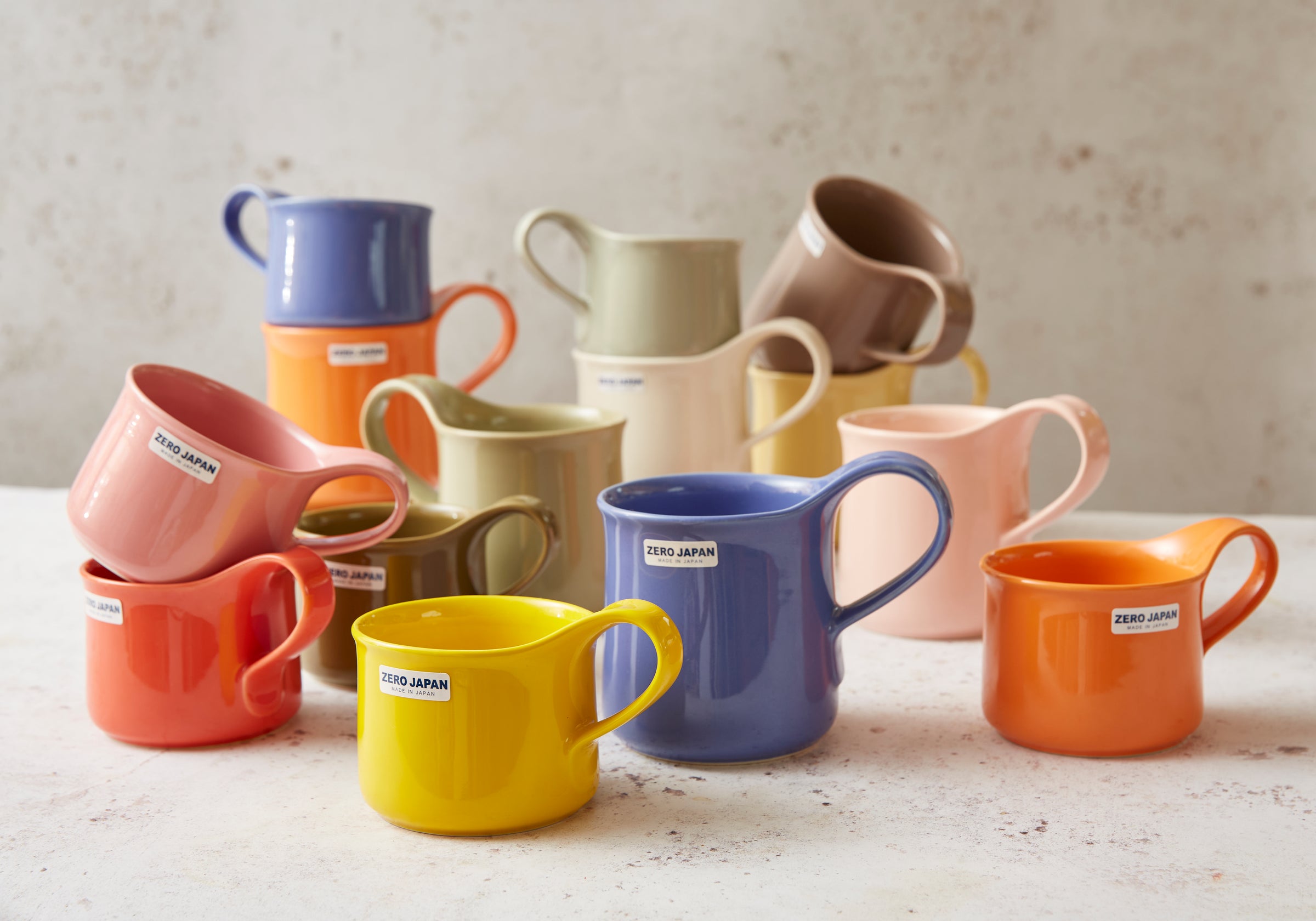 Colorful Zero Japan mugs on a light surface with a neutral background